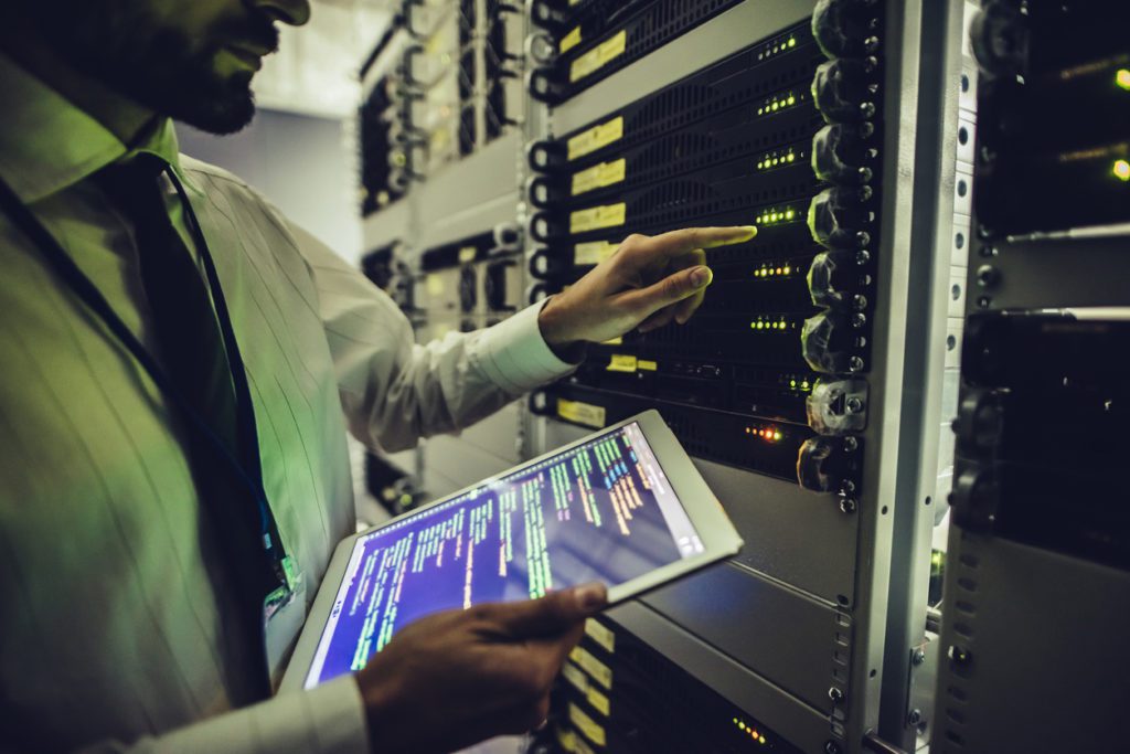 Man in server room maintaining data servers for cyber security under OpSec