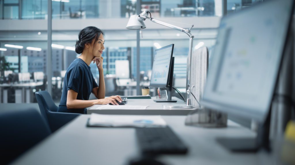 A manager using desktop computer to review software licenses.